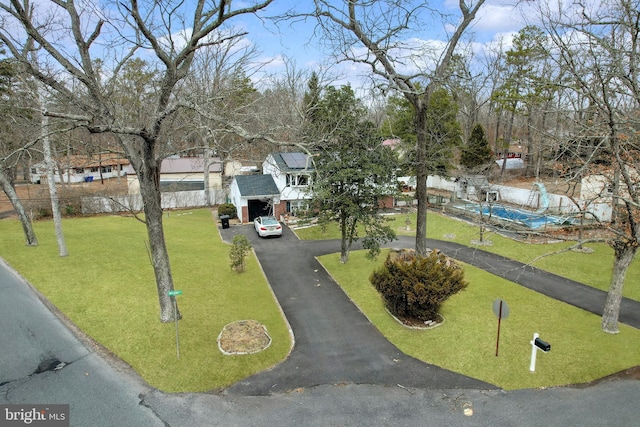 view of community featuring a lawn and driveway