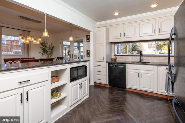 kitchen with dark stone countertops, ornamental molding, black appliances, and a sink