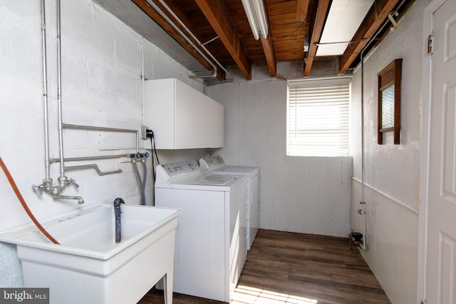 clothes washing area with a sink, wood finished floors, and separate washer and dryer