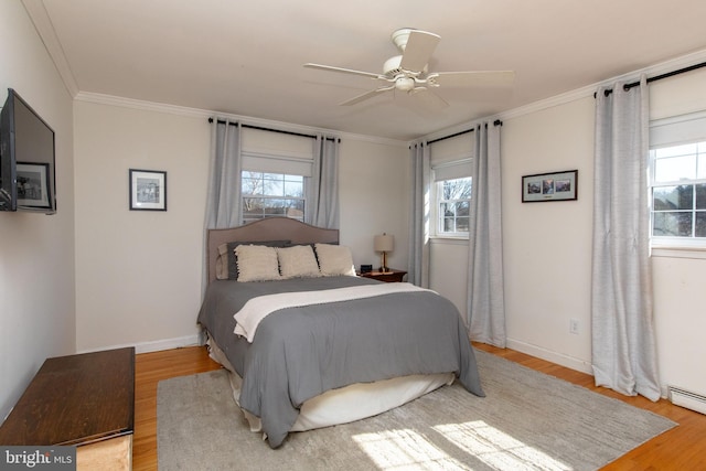 bedroom with crown molding, multiple windows, and wood finished floors