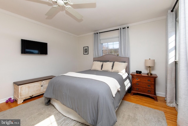 bedroom featuring ornamental molding, baseboards, ceiling fan, and wood finished floors