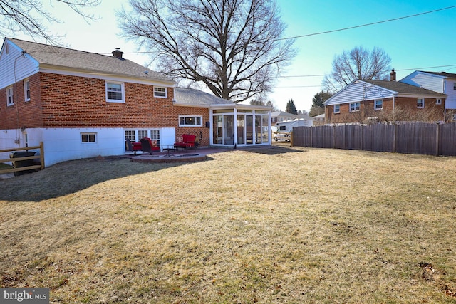 view of yard with fence, a patio, and a sunroom