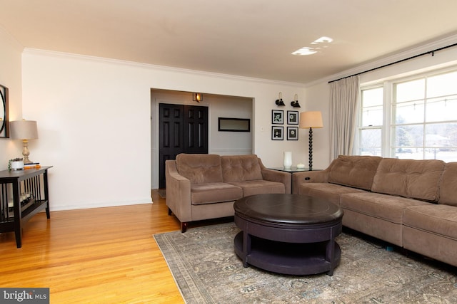 living room with baseboards, wood finished floors, and ornamental molding