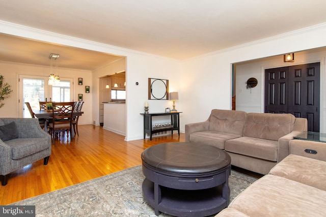 living area with ornamental molding, baseboards, and wood finished floors