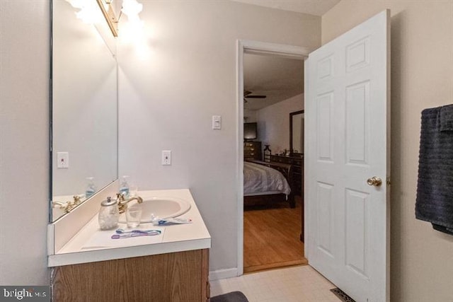 bathroom featuring connected bathroom, vanity, baseboards, and tile patterned floors