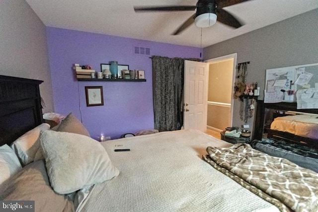 bedroom featuring a fireplace and a ceiling fan