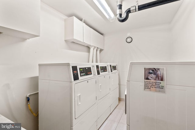 shared laundry area with light tile patterned flooring and washing machine and clothes dryer