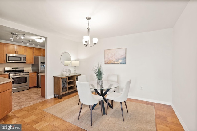 dining room with baseboards and a chandelier