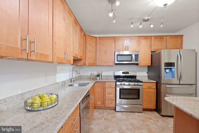 kitchen with stainless steel appliances, a sink, and light stone counters