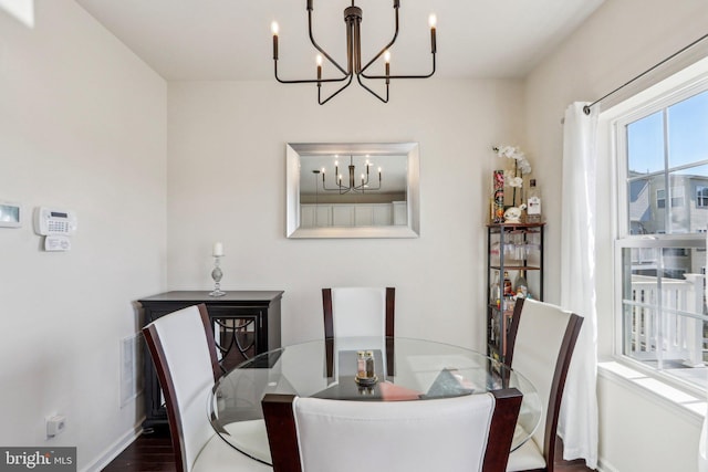 dining area with a chandelier, wood finished floors, and baseboards