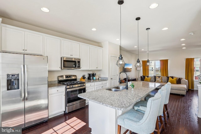 kitchen with dark wood-type flooring, stainless steel appliances, a sink, and open floor plan