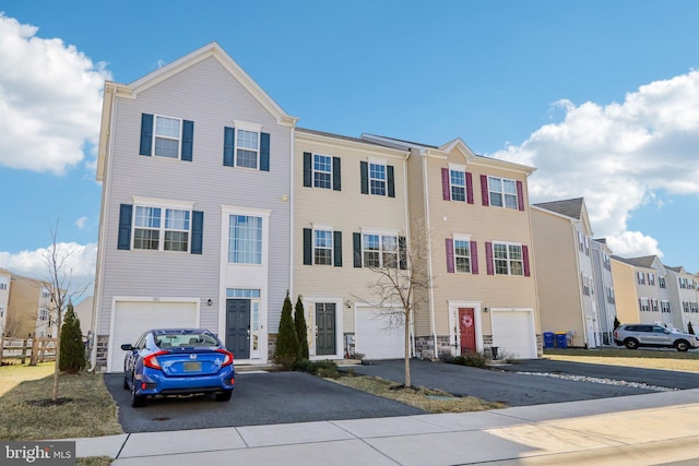 view of front of property featuring a residential view, driveway, and an attached garage