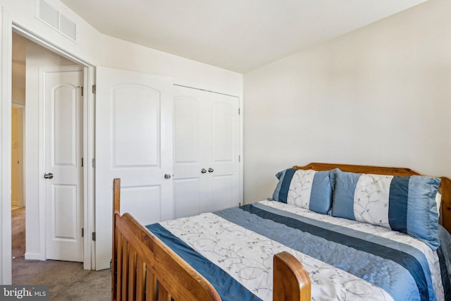 carpeted bedroom with a closet and visible vents