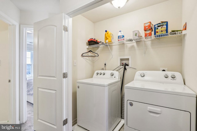 laundry area featuring laundry area, separate washer and dryer, and light colored carpet