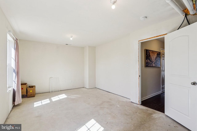 spare room featuring unfinished concrete floors