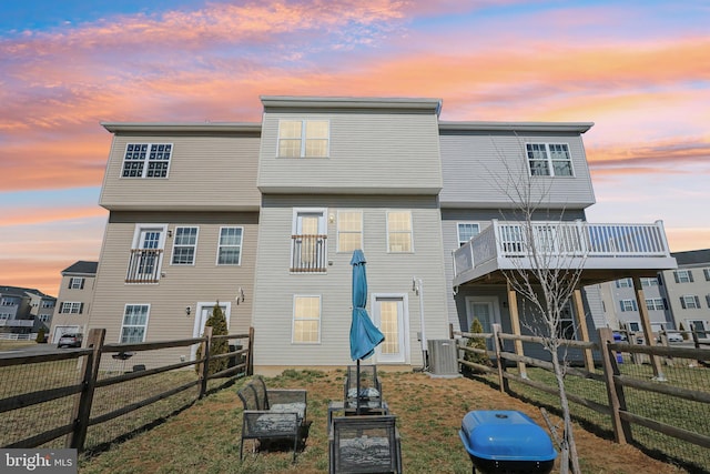 rear view of property with central AC and fence