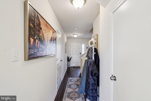 corridor featuring baseboards and wood finished floors