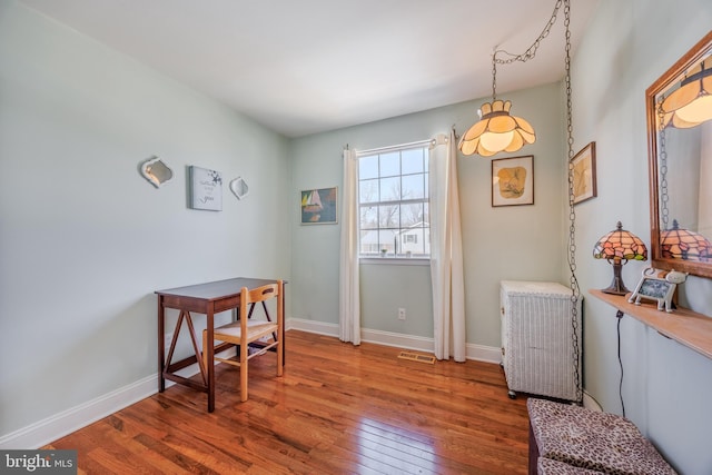 office with hardwood / wood-style floors, visible vents, and baseboards