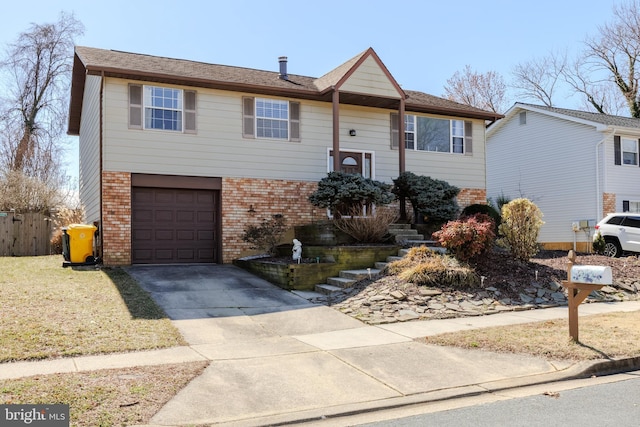 bi-level home with driveway, a garage, stairs, a front lawn, and brick siding