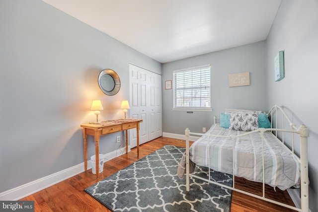 bedroom featuring a closet, baseboards, and wood finished floors