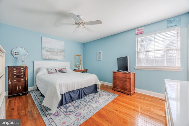 bedroom with a ceiling fan, hardwood / wood-style flooring, and baseboards