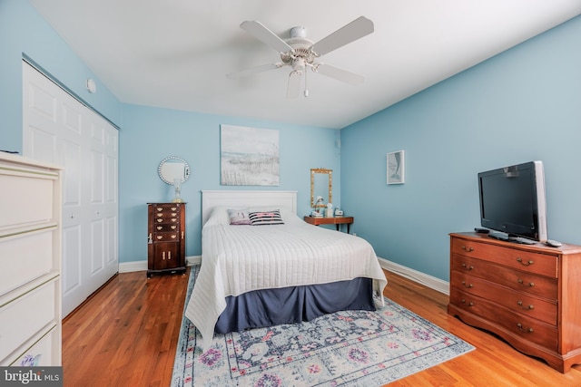 bedroom with ceiling fan, baseboards, and wood finished floors