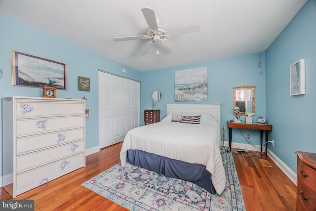 bedroom with a ceiling fan, a closet, baseboards, and wood finished floors