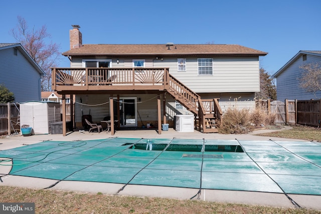 back of house with a chimney, stairway, fence, a deck, and a patio area