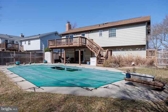 rear view of property with an outdoor structure, fence, stairs, a wooden deck, and a patio area