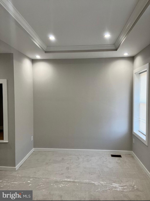 unfurnished room featuring a tray ceiling, crown molding, recessed lighting, visible vents, and baseboards