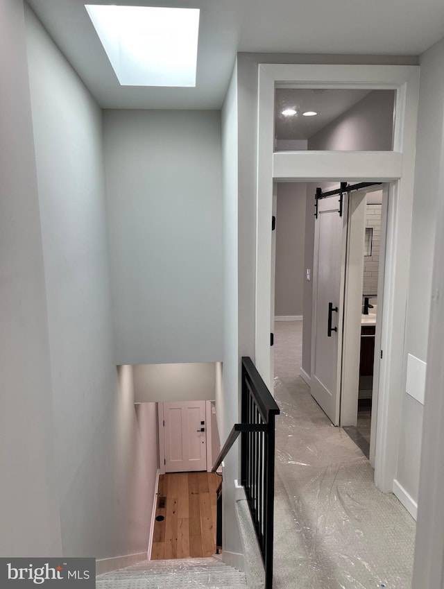 stairs with a skylight and wood finished floors