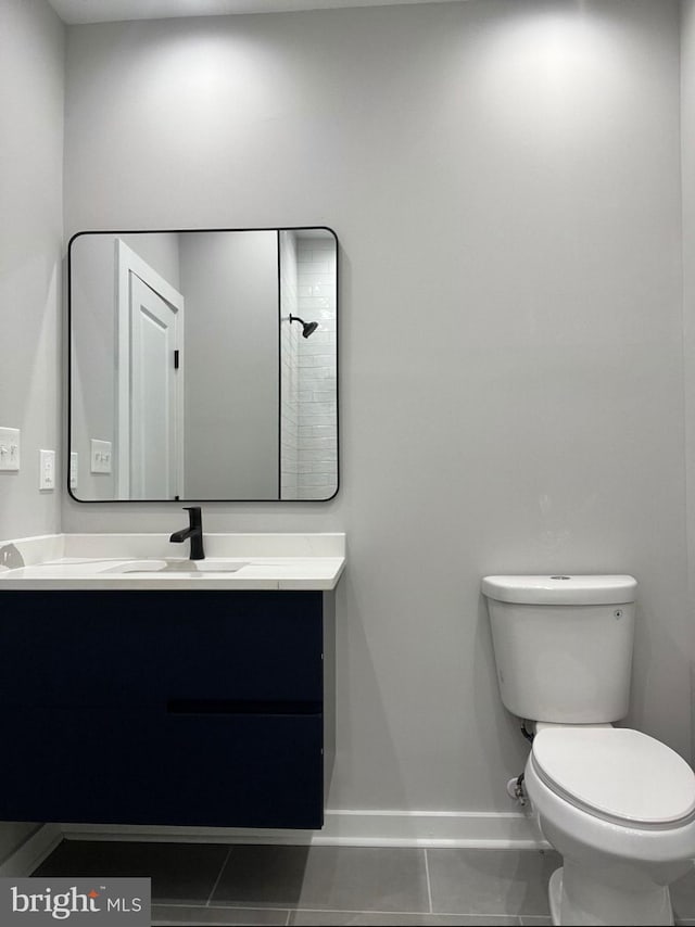 bathroom featuring baseboards, vanity, and toilet