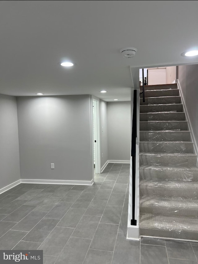 finished below grade area with recessed lighting, baseboards, and stairs