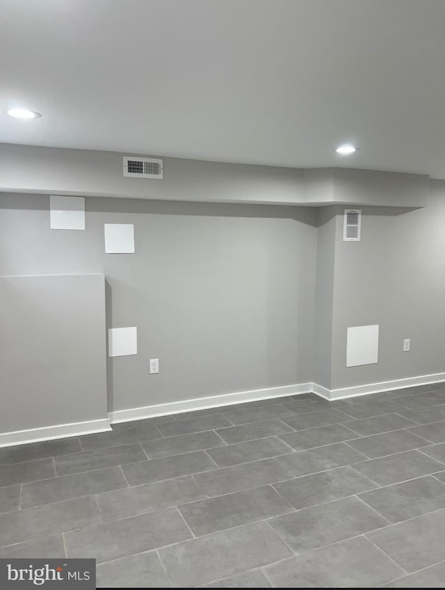 finished basement featuring baseboards, visible vents, and recessed lighting