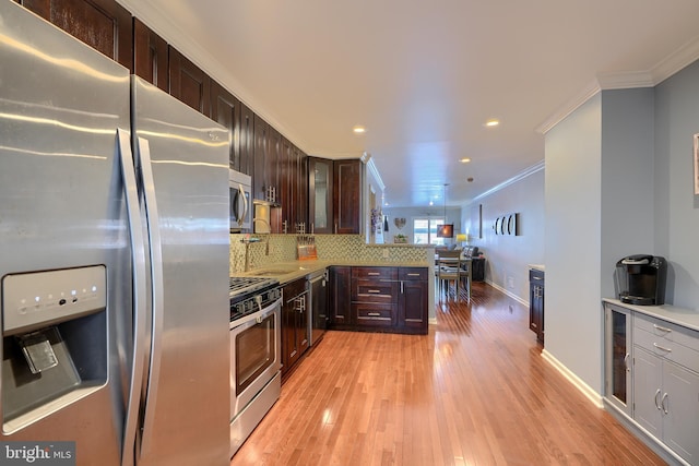 kitchen featuring stainless steel appliances, decorative backsplash, glass insert cabinets, light wood-style floors, and crown molding