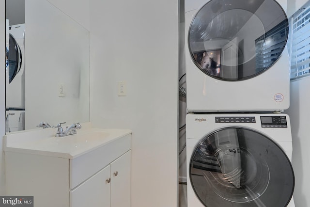 washroom with a sink, laundry area, and stacked washing maching and dryer