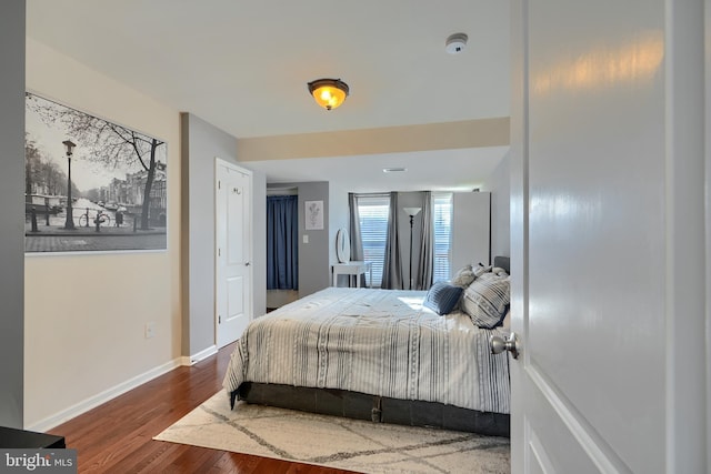 bedroom featuring baseboards and wood finished floors