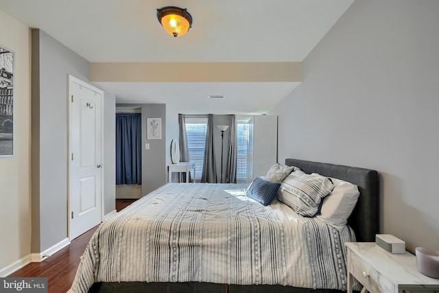 bedroom featuring dark wood-style floors, visible vents, and baseboards