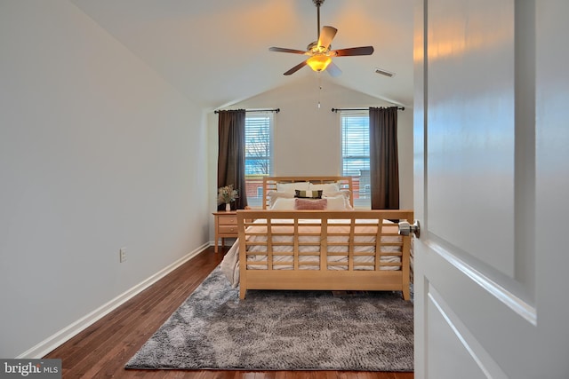 bedroom featuring dark wood finished floors, lofted ceiling, baseboards, and visible vents