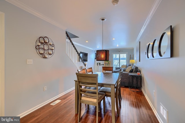 dining area with visible vents, crown molding, baseboards, and hardwood / wood-style floors