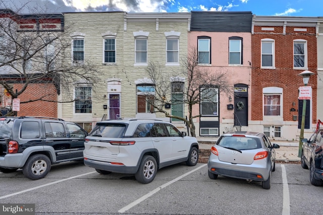 townhome / multi-family property featuring brick siding and uncovered parking