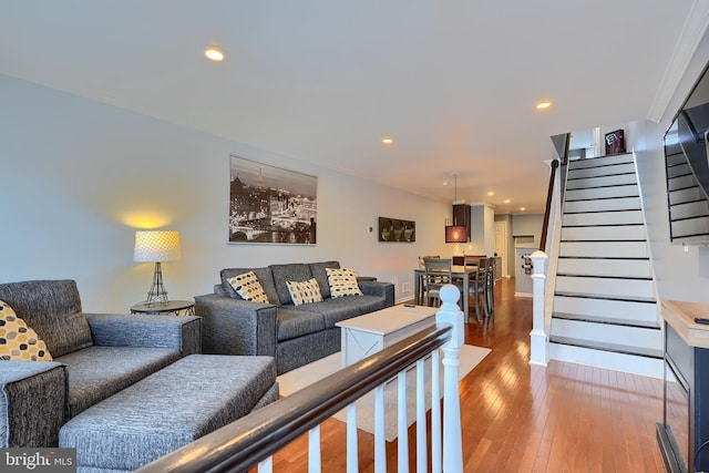 living area with recessed lighting, crown molding, stairs, and wood-type flooring