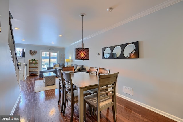 dining room with visible vents, crown molding, dark wood-type flooring, and baseboards