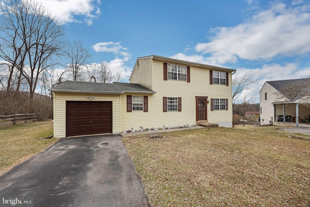 view of front of property featuring a front yard, fence, driveway, an attached garage, and entry steps