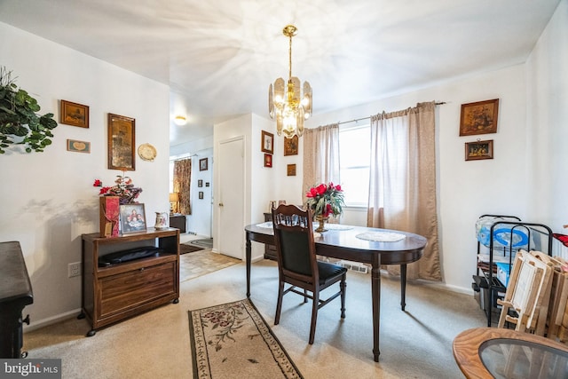 dining room with an inviting chandelier, baseboards, and light carpet