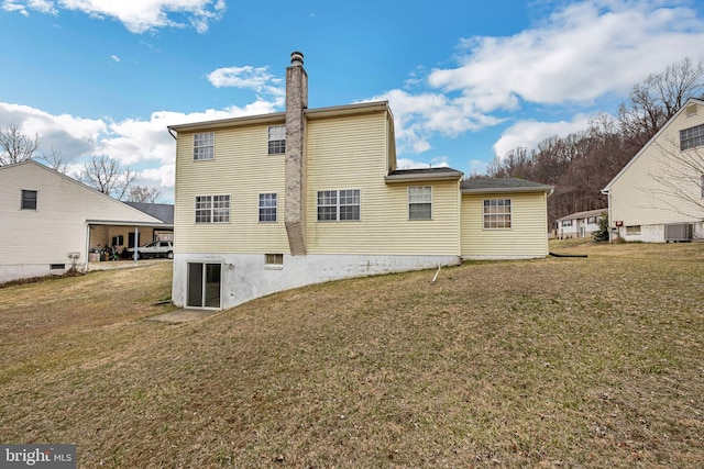 back of property featuring a yard, central AC unit, and a chimney