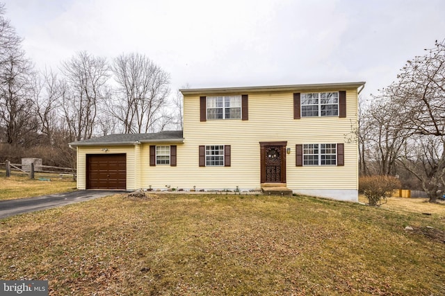 view of front facade with a garage, a front yard, driveway, and fence