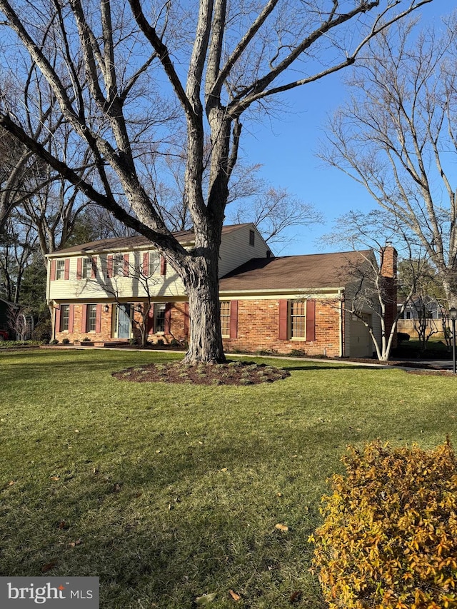 colonial-style house with a front lawn and brick siding