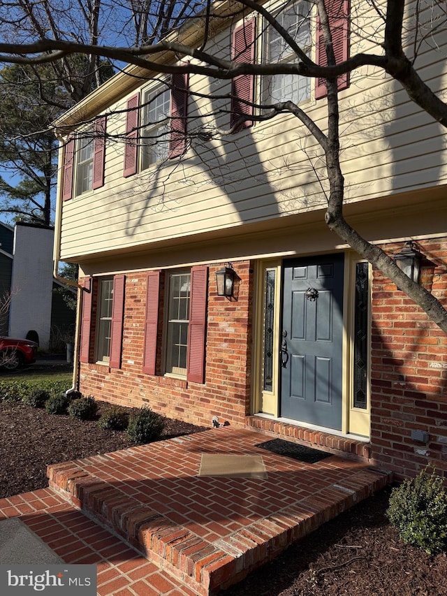 doorway to property featuring brick siding