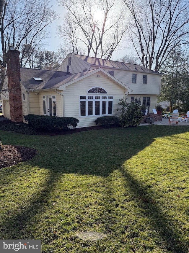 view of front of home with a patio, a chimney, and a front lawn